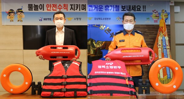 22일 하이트진로 김인규 대표(왼쪽)와 경북소방본주 김종근 본부장이 비대면으로 수상안전캠페인 물품 전달식을 진행했다./사진=하이트진로