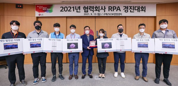 LG전자 김병수 동반성장담당(왼쪽에서 다섯 번째), 엠에스이 김유숙 대표이사(네 번째) 등이 13일 경남 창원시 창원R&D센터에서 화상회의 형식으로 개최된 협력회사 RPA 경진대회에서  협력사들과 우수사례를 공유하고 기념촬영을 하고 있다./사진=LG전자