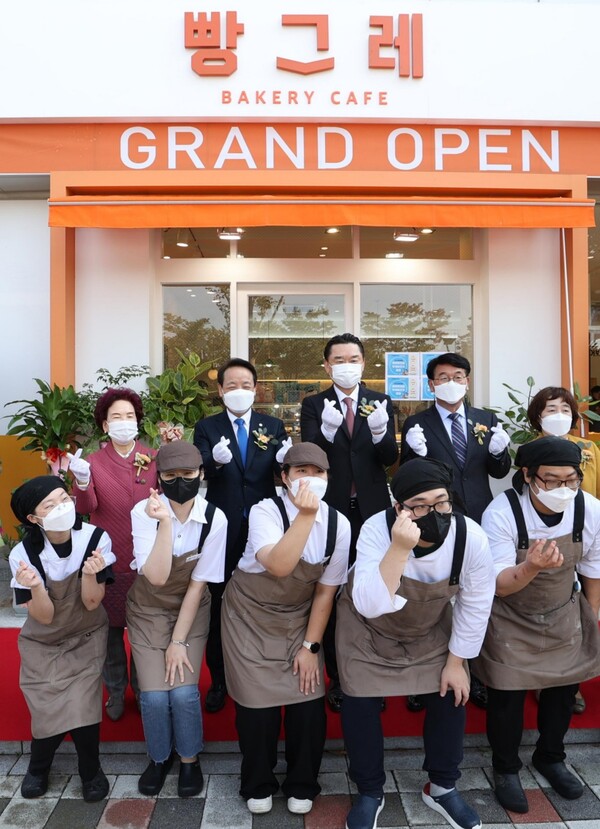 청년자립 지원사업 빵그레 2호점 개소식 행사 중 하이트진로 김인규 대표(뒷줄 왼쪽 세번째), 임택 동구청장(뒷줄 왼쪽 두번째) 등 관계자들과 자활근로 청년들이 함께 기념촬영을 하고 있다./사진=하이트진로