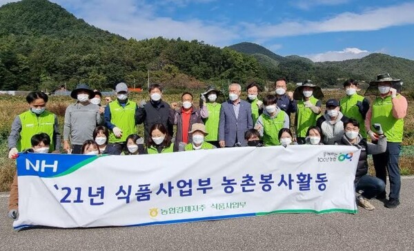 농협경제지주 식품사업부 직원들이 25일 경북 안동시에 위치한 고추농가를 찾아 일손 돕기를 실시하고 기념 촬영을 하고 있다./사진=농협
