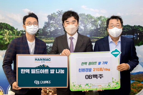 5일 오비맥주는 필드아트로 수확한 쌀을 취약계층에 전달했다. (왼쪽부터) 윤현탁 오비맥주 마케팅 부장, 유희문 오비맥주 마케팅 부사장, 이상천 제천시장이 기탁식에서 기념사진을 찍고 있다./사진=오비맥주