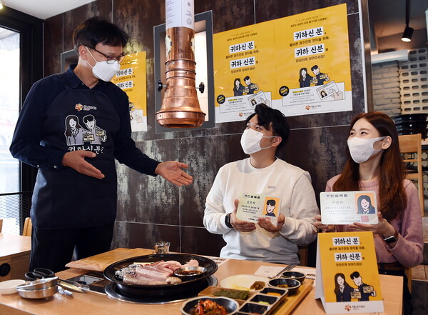 오비맥주 법무·정책홍보 부문 구자범 수석 부사장(오른쪽에서 두번째)이 직원들과 강남구 삼성동 인근 음식점을 방문해 주류 판매 시 신분증을 확인하는 '귀하 신분' 캠페인을 펼치고 있다./사진=오비맥주