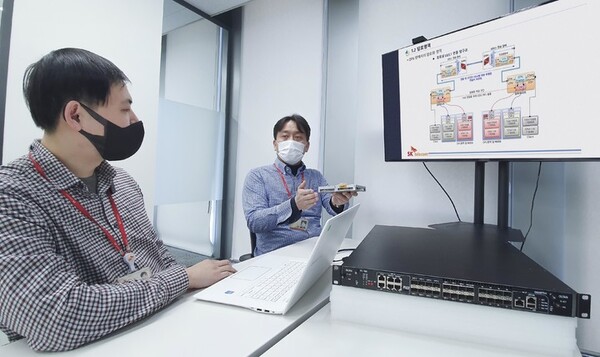 사진은 SK텔레콤 직원들이 KCMVP 인증 암호모듈 및 해당 모듈이 설치된 전송장비에 대해 논의하고 있다. /사진=SK텔레콤