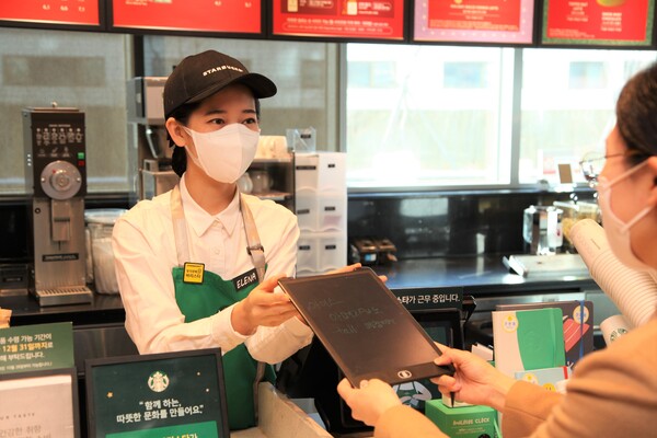 스타벅스 서울대치과병원점에서 근무중인 청각장애인 최예나 점장이 고객에게 주문내용을 확인하고 있다./사진=스타벅스