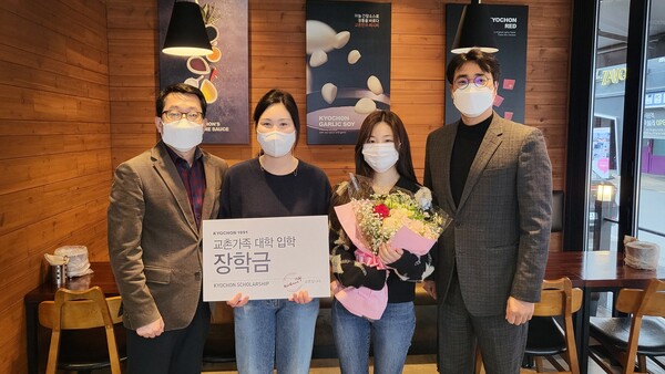 교촌에프앤비 관계자가 장학금 수혜 가맹점주 가족과 기념사진 촬영을 하고 있다./사진=교촌에프앤비