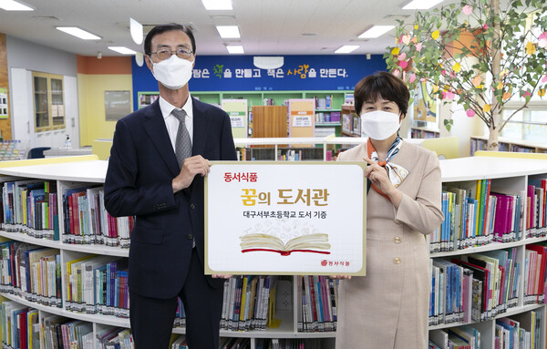 3일 대구 서구에 위치한 대구 서부초등학교에서 진행된 ‘2022 동서식품 꿈의도서관’ 도서 기증식에서 (왼쪽부터) 동서식품 최상인 홍보상무와 대구서부초 이미경 교장이 기념사진을 촬영하고 있다./사진=동서식품
