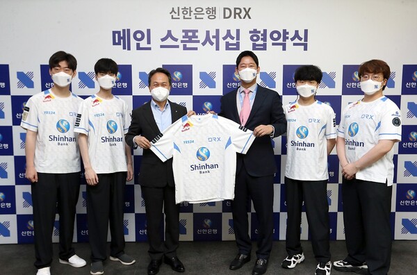 23일 서울 마포구 DRX 본사에서 진행된 스폰서십 체결식에서 신한은행 진옥동 은행장(왼쪽 세 번째)과 DRX 최상인 대표(왼쪽 네 번째)가 체결식이 끝난 후 DRX 소속 선수들과 기념촬영을 하고 있다./사진=신한은행