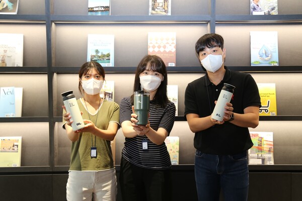 DL이앤씨 직원들이 ‘종이컵 제로’ 캠페인을 위해 지급받은 개인 컵을 들고 사진 촬영하고 있다./DL이앤씨