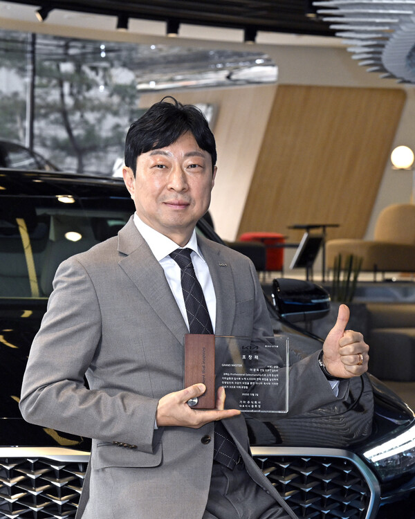 기아 서울 상암지점 이광욱 선임 오토컨설턴트가 누적 판매 대수 4000대 달성 상패를 들고 기념촬영을 하고 있다./사진=기아