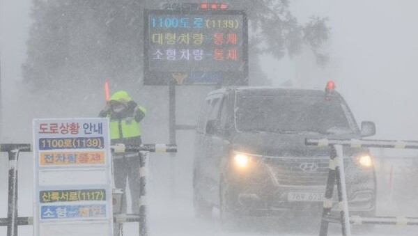 설 연휴 마지막 날이자 폭설이 시작된 24일 오전 제주시 해안동 축산진흥원 앞에서 경찰이 산간도로 출입을 통제하고 있다./사진=연합