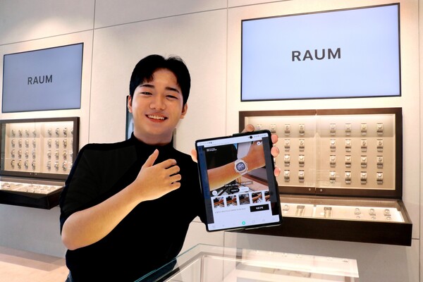 라움워치에서 모델이 AR 서비스를 시현해보고 있다./LF