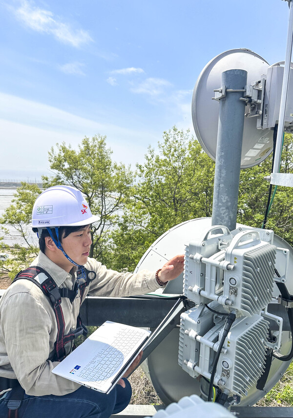 SKT 직원들이 도서 지역에 설치된 5G 마이크로웨이브 통신 장비를 점검하는 모습./SKT