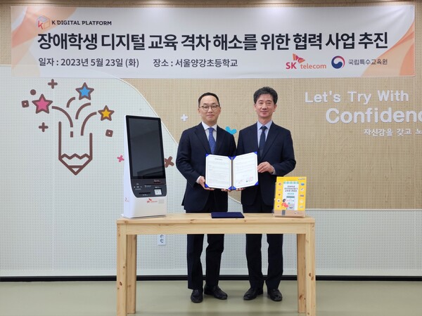 23일 SKT와 교육부 국립특수교육원은 서울 양천구 양강초등학교 특수학급을 대상으로 장애학생용 무인정보단말기(키오스크) 프로그램 활용 교육을 실시했다. 엄종환 SK텔레콤 ESG 얼라이언스 담당(왼쪽)과 이한우 국립특수교육원장이 기념촬영을 하고 있다./SKT