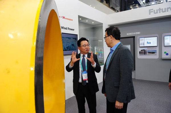 박경일 SK에코플랜트 사장(왼쪽)과 이승철 SK오션플랜트 대표가 25일 부산 벡스코에서 열린 제1회 기후산업국제박람회에 전시된 SK오션플랜트 후육강관 실물 앞에서 이야기를 나누고 있다. 두꺼운 철판을 구부려 만드는 후육강관은 SK오션플랜트 해상풍력 하부구조물 글로벌 경쟁력의 원천이다. 이날 전시된 후육강관의 두께는 15cm, 무게는 약 9톤에 이른다. / SK에코플랜트