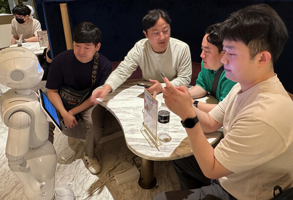 LG유플러스는 지난달 30일부터 7월 14일까지 직원들을 대상으로 '우수사원 해외연수 프로그램'을 진행한다. 프로그램에 참여한 직원들이 일본 도쿄 페퍼 팔러 카페에서 서비스 로봇 이용 체험을 하고 있다./사진=LG유플러스