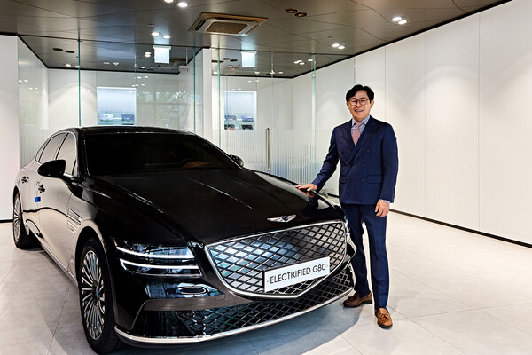 누적 판매 7000대를 달성한 최진성 현대차 영업이사가 제네시스 G80 전동화 모델 앞에서 기념사진을 촬영하고 있다./사진=현대자동차