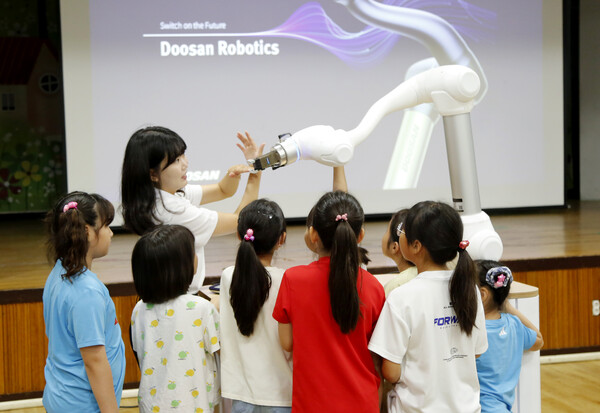 두산로보틱스 임직원이 아이들에게 협동로봇의 개념과 작동 과정 등을 교육하고 있다. /두산로보틱스