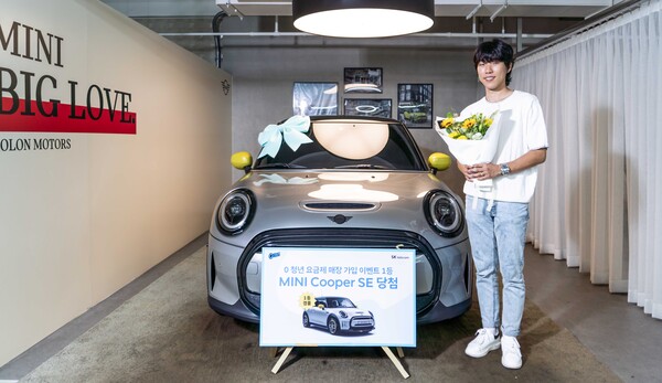 SKT 0 청년 요금제 출시 기념 경품 이벤트에서 1등에 당첨돼 BMW 미니 쿠퍼 전기차를 받은 정태성씨(왼쪽)가 차량 앞에서 기념사진 촬영을 하고 있다./사진=SK텔레콤