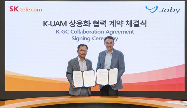 SK텔레콤은 글로벌 UAM 기체 제조사 조비와SK T타워에서 한국형 UAM 상용화를 위한 협력 계약을 체결했다고 20일 밝혔다. SK T타워에서 열린 협약식에서 하민용 SKT CDO(왼쪽), 에릭 앨리슨 조비 부사장(오른쪽)이 계약을 체결하고 기념촬영을 하고 있다./SKT