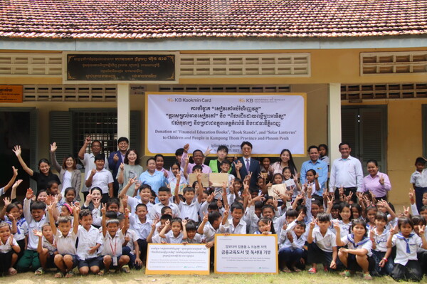 2023년 11월 7일 캄보디아 프놈펜에서 진행된 기부 물품 전달식에서 KB국민카드 현지법인 KB대한특수은행 임직원들과 운롱깐초등학교 아이들이 기념촬영을 하고 있다. /사진=KB국민은행