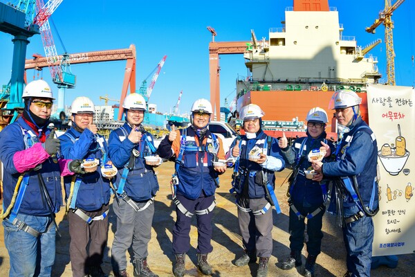 2023년 12월 21일 HD현대중공업 생산현장 근로자들이 어묵탕을 들고 기념사진을 촬영하고 있다. /HD현대중공업