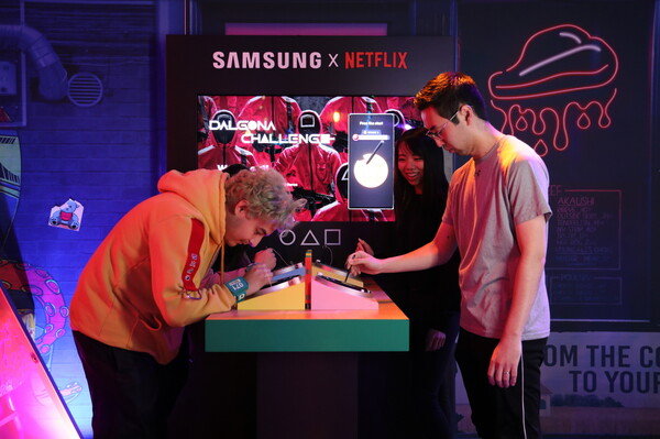 넷플릭스 오징어게임:더트라이얼 참가자들이 갤럭시 S23 울트라의 S펜으로 디지털 달고나 게임을 즐기고 있다./사진=삼성전자