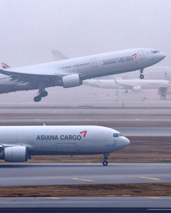  2023년 10월 31일 인천국제공항 활주로에서 착륙한 아시아나 화물기가 이동하는 사이 여객기가 이륙하고 있다./연합