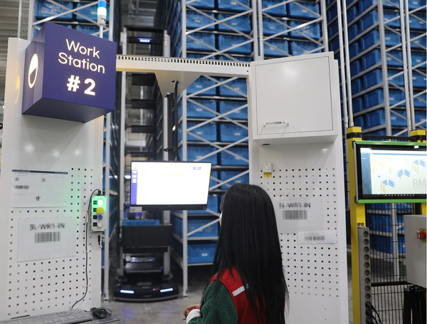 G마켓 동탄메가센터에서 두 가지 종류의 로봇이 협업해 작업자가 있는 작업대까지 상품을 이송하고 있다./사진=G마켓