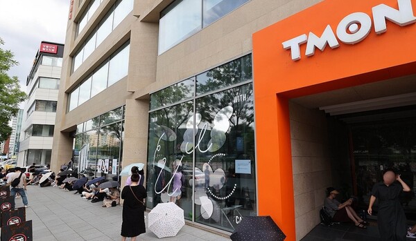 싱가포르 기반의 전자상거래(이커머스) 플랫폼 큐텐 계열사인 위메프와 티몬 정산 지연 사태가 점차 확산되고 있는 25일 서울 강남구 티몬 본사 앞에서 환불을 원하는 피해자들이 우산을 쓰고 사측을 기다리고 있다./연합뉴스