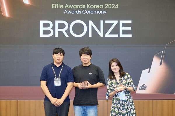 오비맥주의 크리에이티브 조직 '드래프트라인' 소속의 류원기 Director(중앙), 오지은 BXD. Sr. Manager(우측)가 '2024 에피 어워드 코리아' 시상식에서 기념 촬영을 하고 있다. /사진=오비맥주