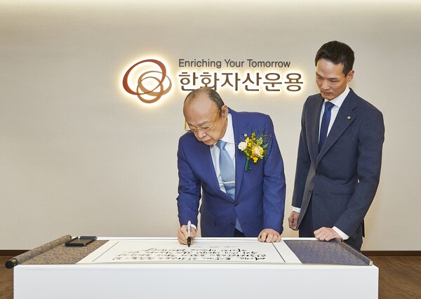 김승연 한화그룹 회장이 차남 김동원 한화생명 사장과 2024년11월5일 서울여의도 63빌딩 한화자산운용 본사를 찾아 방명록을 작성하고 있다./사진=한화