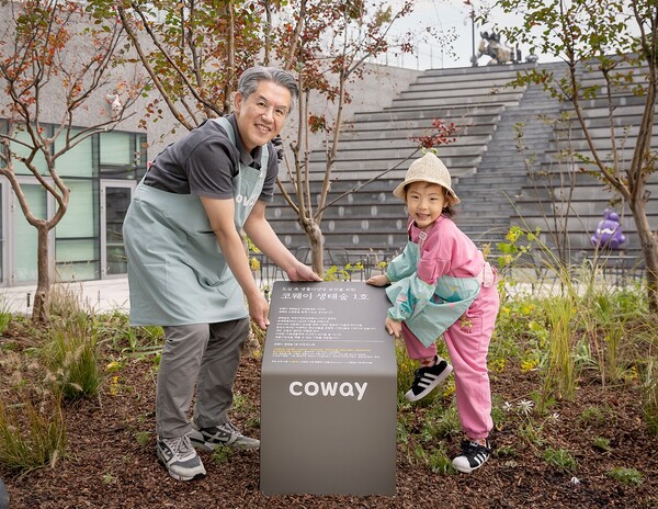 서장원 코웨이 대표와 임직원 자녀가 '코웨이 생태숲 1호' 현판 앞에서 기념 촬영을 하고 있다./코웨이