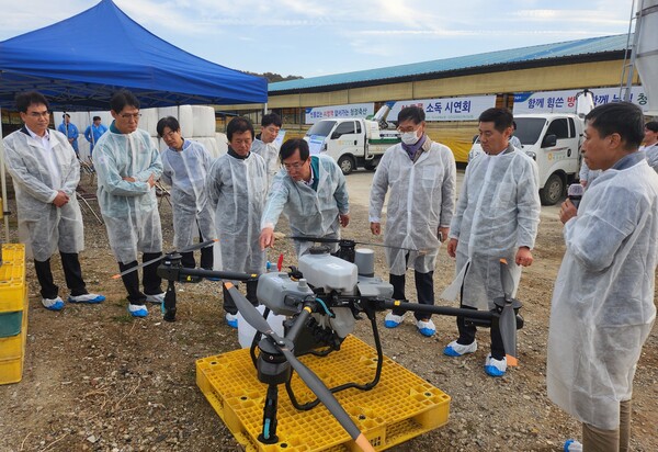 안병우 농협경제지주 축산경제대표이사(사진 오른쪽에서 네 번째)가 2024년 11월 4일 인천광역시 강화군 축산농가에서 열린 조류인플루엔자 예방 드론 소독 시연회에서 드론에 대한 설명을 듣고 있다. / 사진=농협