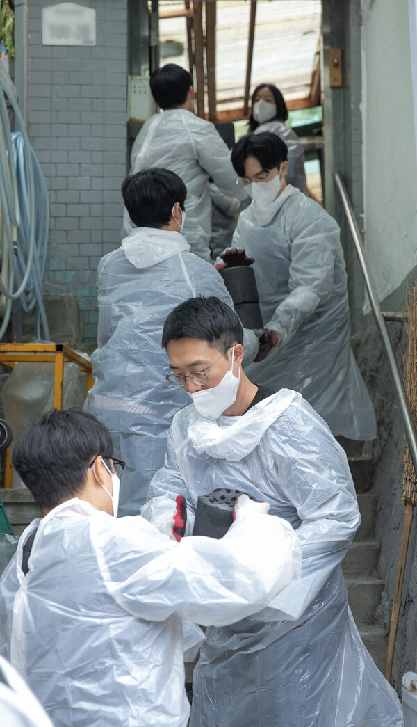 동서식품 임직원들이 20일 서울시 서대문구 홍제동 개미마을 이웃들을 위해 연탄을 나르고 있다./동서식품
