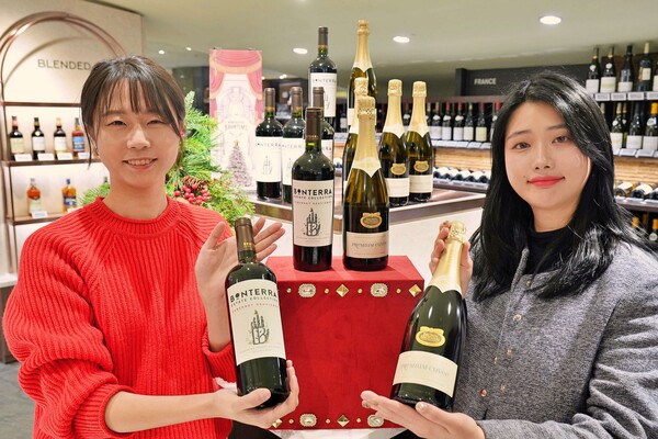 롯데백화점이 21일부터 서울의 심판 1위의 영예에 오른 레드·스파클링 와인을 각각 2500병 한정으로 판매한다. 사진은 서울의 심판 우승 와인을 들고 있는 모델./사진=롯데쇼핑.