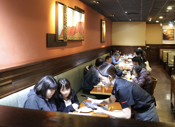 2024년 12월 23일 다이닝브랜즈그룹이 아웃백 충청남도 천안펜타포트점에서 가족돌봄 천소년 가정과 함께 식사를 나누고 기념사진을 촬영하고 있다. /다이닝브랜즈그룹