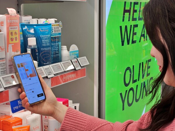 올리브영 매장에서 한 고객이 ‘전자라벨-NFC 기반 상품 탐색 서비스’를 이용하고 있는 모습 /2025.1.21.CJ올리브영