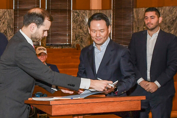 허진수 SPC그룹 사장(가운데)이 1월 27일(현지시각) 미국 텍사스주 존슨 카운티 지방법원에서 진행된 파리바게뜨 제빵공장 투자 인센티브 조인식에서 서명을 하고 있다. / 사진=SPC그룹