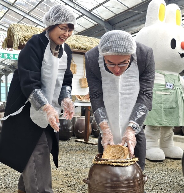 장상우 마트상품부장(사진 오른쪽)이 하나로마트 우수 고객과 함께 2025년 2월 5일 경기도 양편 지평농협에서 소독된 항아리에 메주를 넣고 있다. /농협경제지주