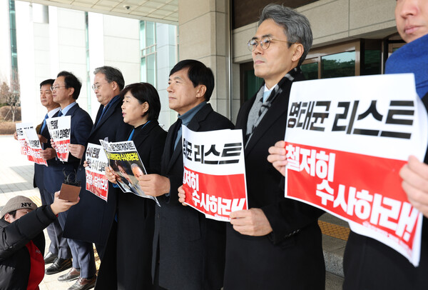 더불어민주당 명태균게이트 진상조사단이 2025년 2월 14일 서울 서초구 대검찰청을 항의 방문하기 전 취재진 앞에서 손팻말을 들고 있다. 왼쪽부터 박균택, 송재봉, 이연희, 서영교, 이성윤, 김기표, 김용만 의원./연합