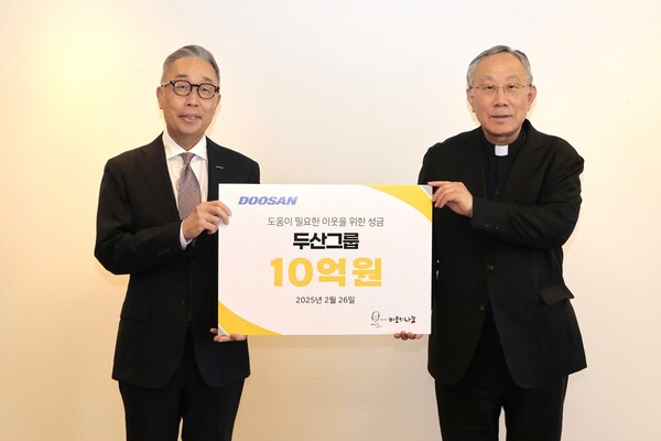 2025년 2월 26일 서울 명동성당에서 열린 성금 전달식에서 박지원 두산그룹 부회장(왼쪽)과 구요비 재단법인 바보의 나눔 이사장이 기념사진을 촬영하고 있다. /두산