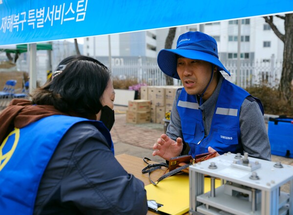 삼성전자서비스 재난복구특별서비스팀 직원이 2025년 3월 28일 경북 의성 실내체육관에 마련된 이재민 대피소에서 가전제품의 무상 점검/수리를 위해 산불 피해 주민과 상담하고 있다. /삼성전자서비스