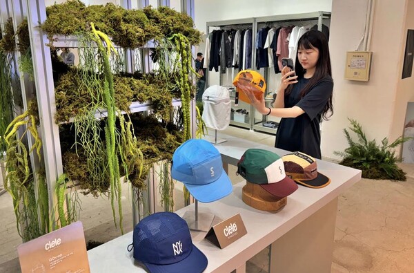 롯데백화점 잠실점 디드턴스 팝업스토에서 모델이 모자를 고르고 있다./2025.4.6.롯데백화점