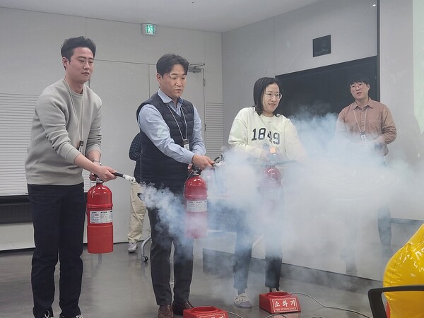 이마트24 임직원들이 위기상황 대응훈련에서 교육용 소화기를 사용해보고 있다. / 사진=이마트24