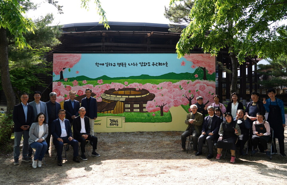 2025년 5월 15일 인천 강화도에 위치한 발달장애인 직업재활시설 강화도 우리마을 외벽 벽화 앞에서 이우봉 풀무원 총괄CEO(사진 첫 번째 줄 왼쪽 두 번째)와 사업단위 대표들이 강화도 우리마을 설립자 대한성공회 김성수 주교(사진 첫 번째 줄 오른쪽 세 번째), 우리마을 최수재 원장 신부(사진 첫 번째 줄 오른쪽 두 번째), 벽화 채색 작업에 참여한 강화도 우리마을 발달장애인 및 근로자들과 단체 사진을 촬영하고 있다. /풀무원