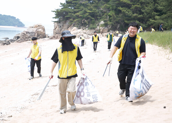 동서식품 임직원들이 2025년 6월 19일 인천 무의도 해안가에서 플로깅 직원 봉사활동을 진행하고 있다. / 사진=동서식품