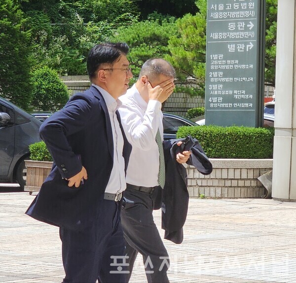 2025년7월1일 서울중앙지법에서 열린 '통행세 부당이득' 재판에 출석하기 위해 (왼쪽에서 두번째) 구자은 LS회장이 얼굴을 감싸쥔채 법정으로 들어가고 있다./사진=문기수 기자