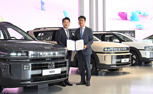 2025년 7월 22일 현대 모터스튜디오 고양에서 김동욱 현대차그룹 부사장(오른쪽), 이호현 산업통상자원부 제2차관이 차량 지원에 관한 협약을 체결하고 현대차 디 올 뉴 넥쏘를 배경으로 기념 촬영을 하고 있다./사진=현대차그룹