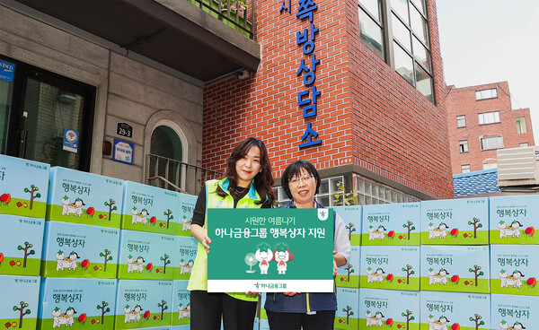 하나금융그룹은 2025년 7월 21일 지역사회 취약계층을 위해 여름철 필수품이 담긴 '시원한 여름나기 행복상자' 1111개를 전달했다. 이날 행사에 참석한 하나금융그룹 직원이 김나나 서울특별시립 창신동쪽방상담소장(사진 오른쪽)에게 행복상자를 전달하며 기념촬영을 하고 있다./사진=하나금융그룹