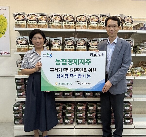 김종희 농협경제지주 경제지원국장(오른쪽)이 2025년 7월 29일 서울역쪽방상담소에서 유호연 소장(왼쪽)에게 삼계탕과 즉석밥을 전달 후 기념촬영을 하고 있다./농협